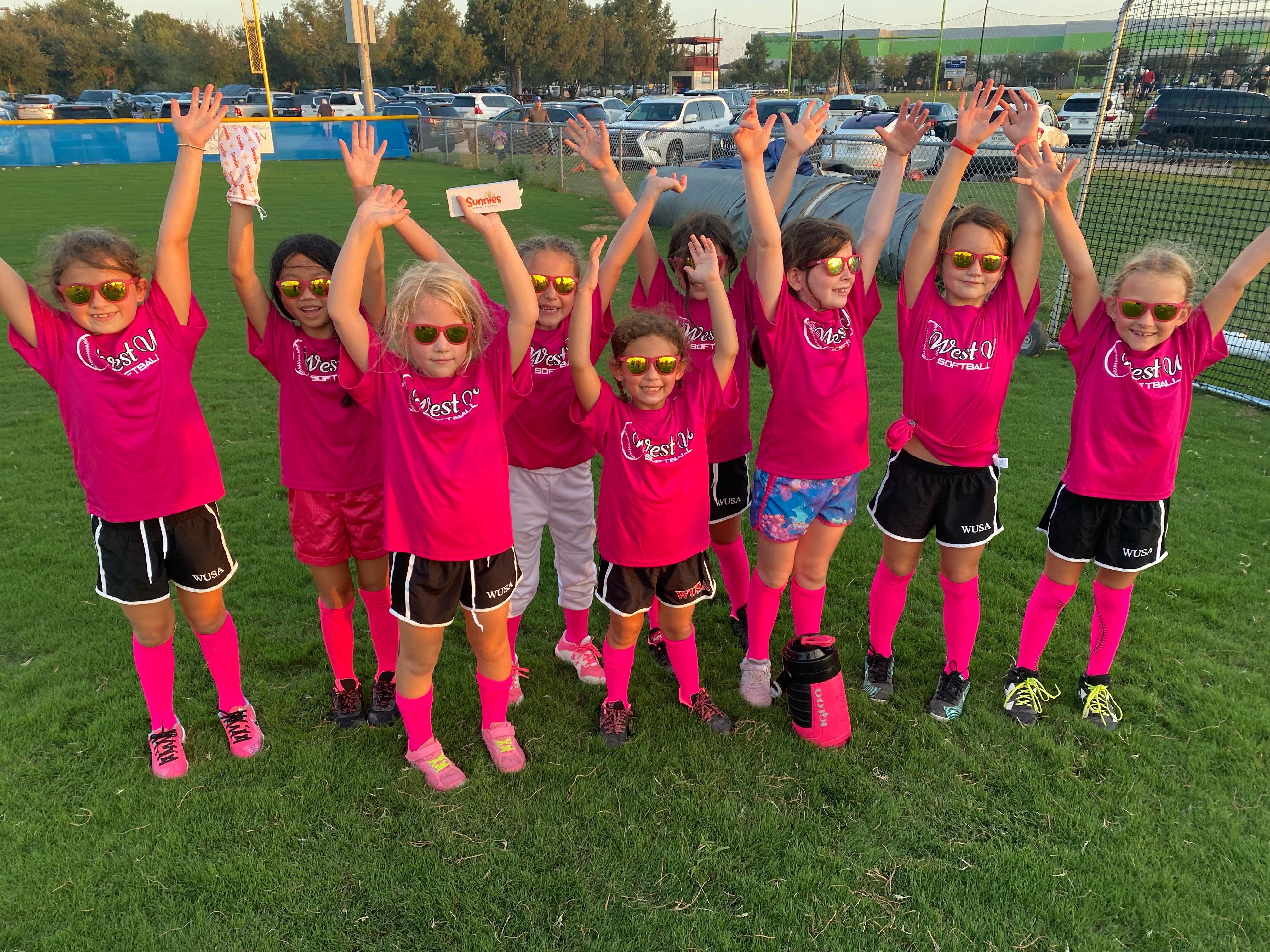 Girl's softball team wearing matching polarized kids sunglasses in a pink frame from Sunnies™