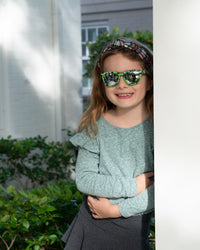 Thumbnail for Little girl wearing sunnies shades kids polarized sunglasses in a green camo print with silver reflective lenses.