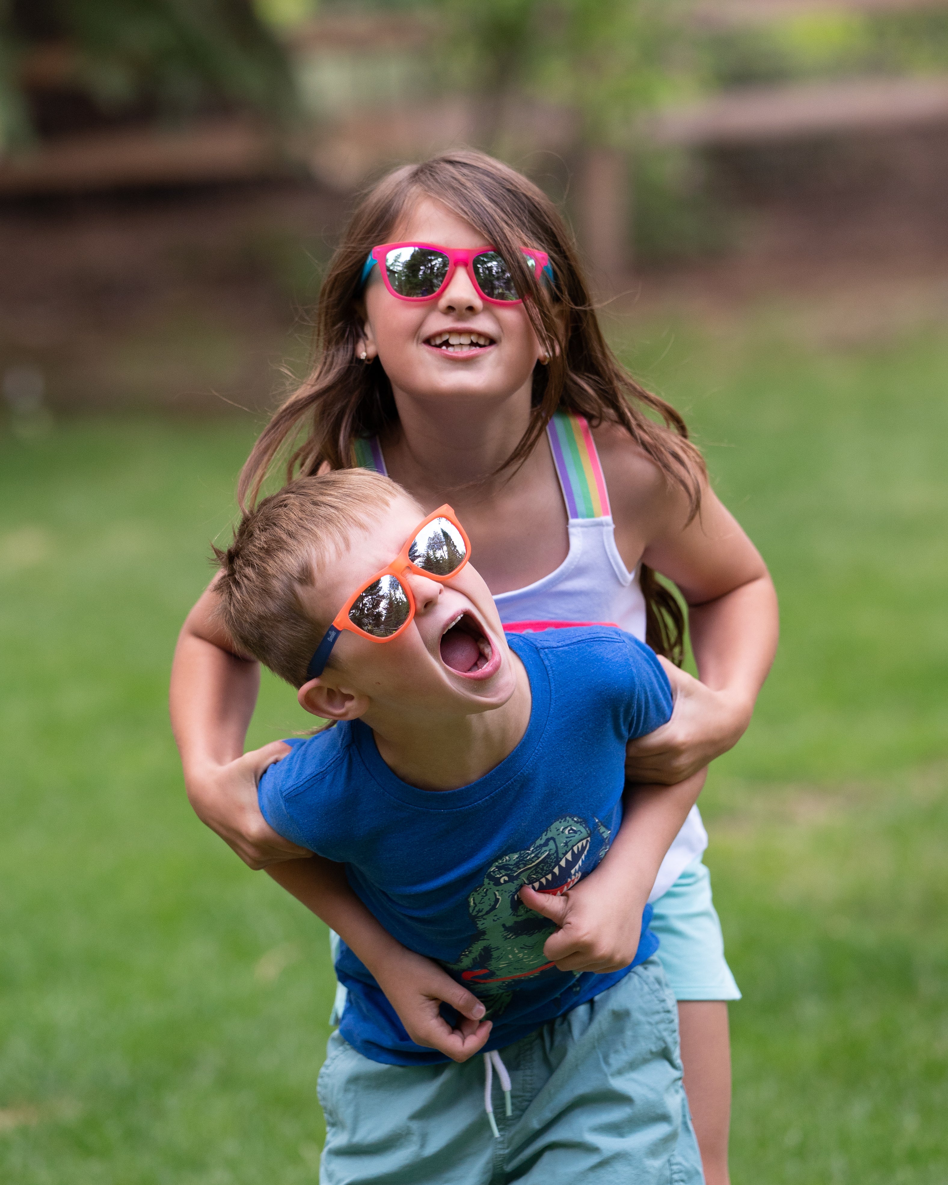 A boy and a girl wearing the new Sunnies shades styles that feature an anti-slip material, polarized lenses and 100% UVA/UVB protection.