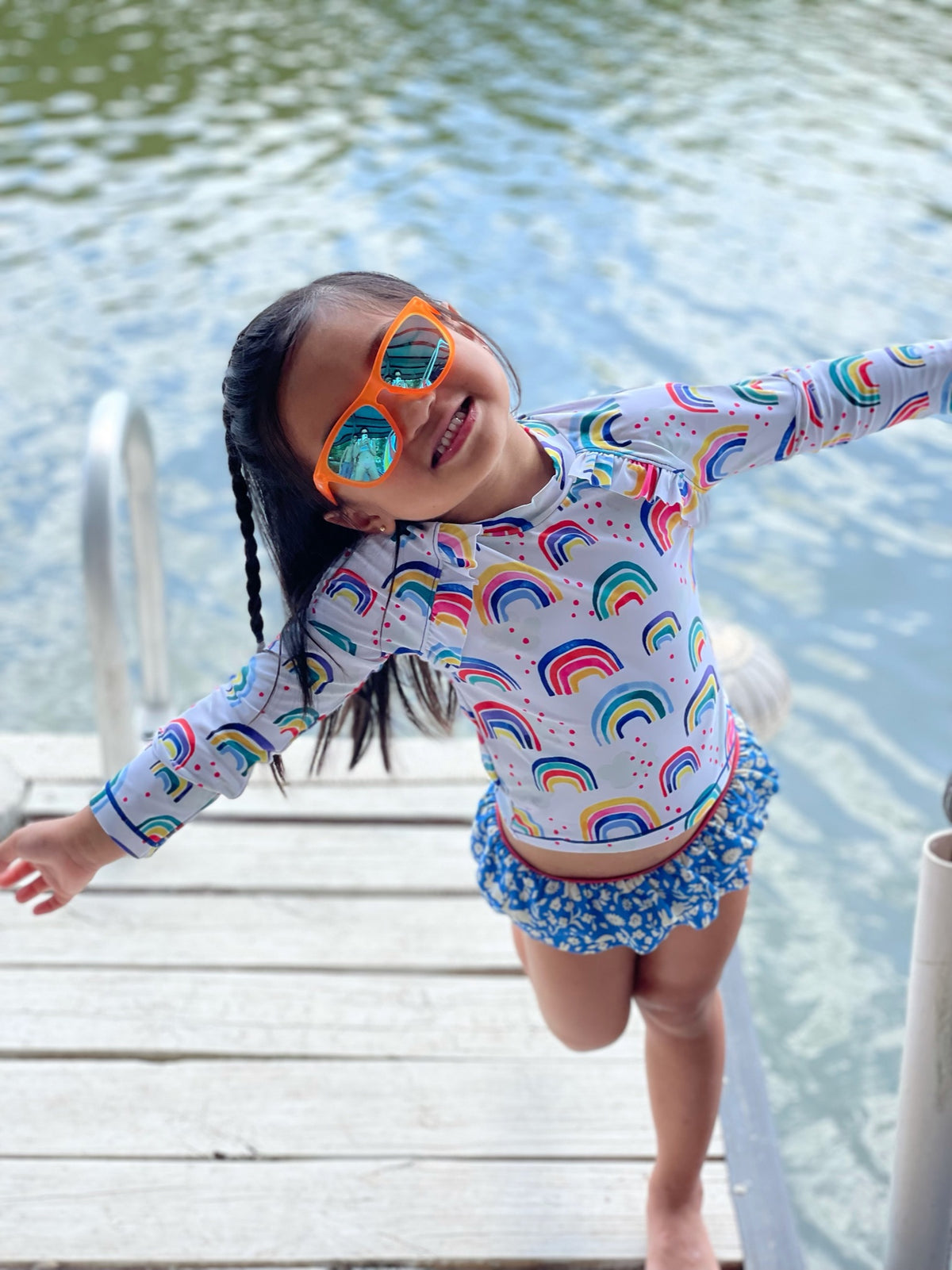 Little girl by a lake wearing Sunnies ™ polarized kids sunglasses with 100% UVA/UVB protection.