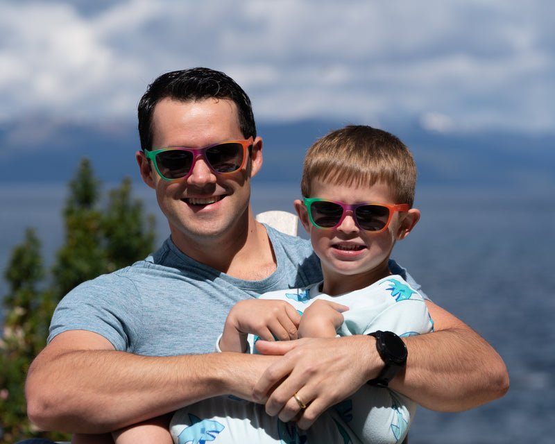 Man and boy wearing the Sunnies Smash Up outdoors by a lake.  The Smash up includes our original sunnies colors smashed into one sunglasses.