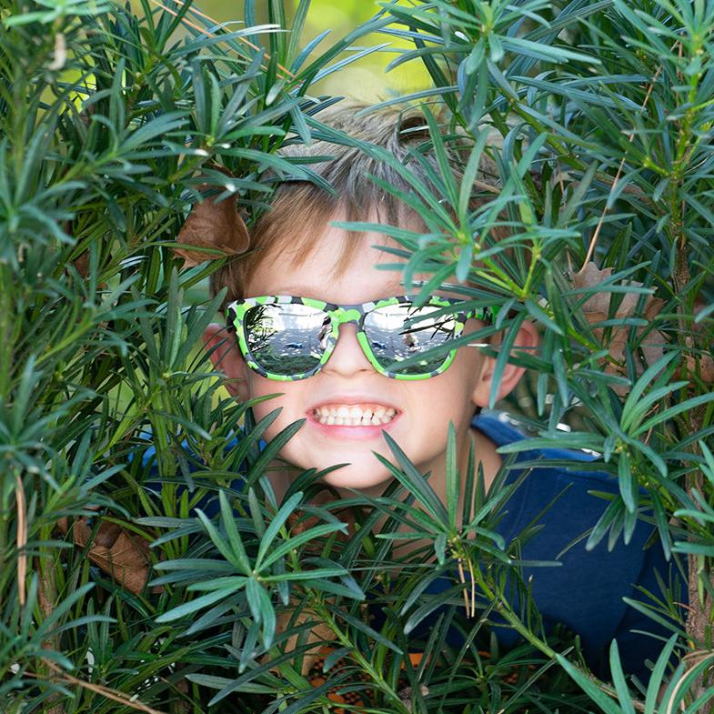 Boy wearing the Now You See Me, Now You Don't polarized sunnies in a green camo frame with reflective silver polarized lenses.