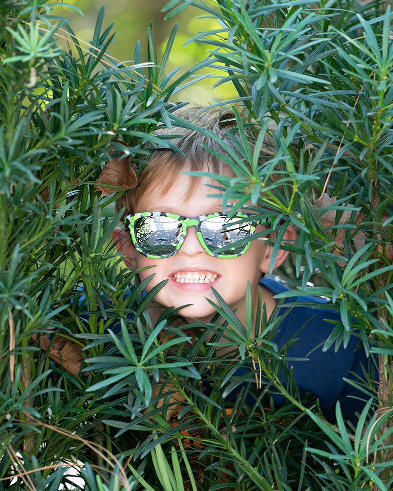 Boy wearing the Now You See Me, Now You Don't polarized sunnies in a green camo frame with reflective silver polarized lenses.