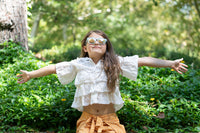 Young girl wearing Wild and Free polarized kids sunglasses with pastel tie dye print and gold reflective lenses.