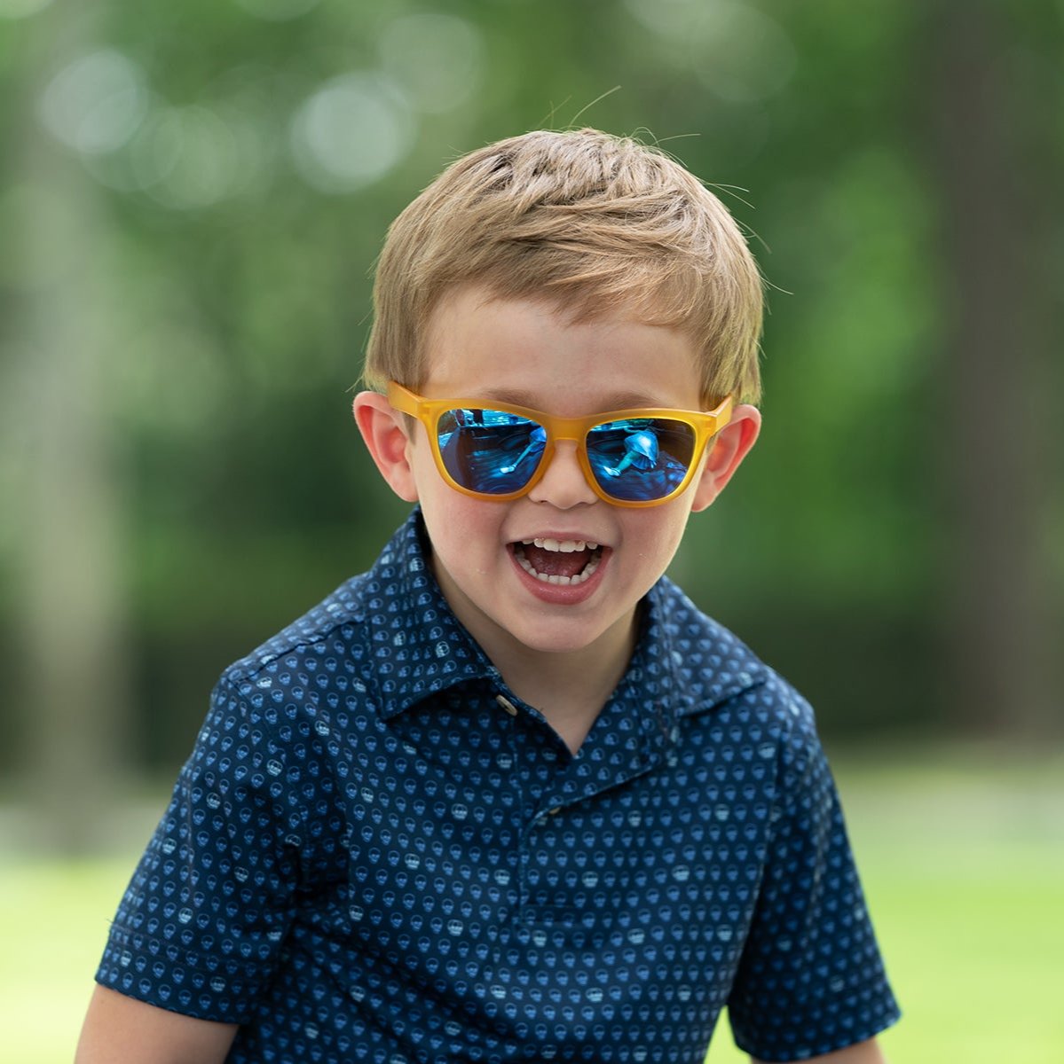 Cute boy wearing Just Monkeying Around polarized sunnies shades with transparent yellow frame and reflective blue polarized lenses