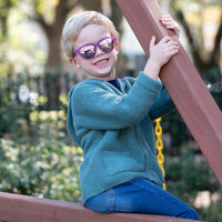 Thumbnail for Little boy playing on a playground while wearing polarized kids sunglasses by Sunnies shades in a transparent purple frame and reflective purple lenses.