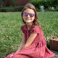 Thumbnail for Little girl wearing sunnies shades polarized kids sunglasses in a transparent purple frame and purple reflective lenses.