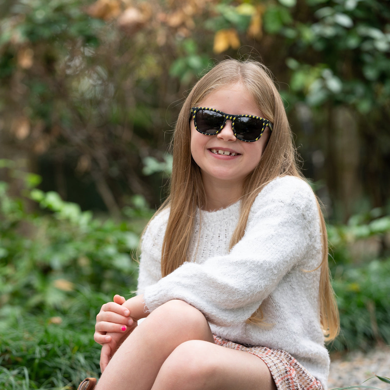 Little girl wearing polarized sunnies shades kids sunglasses in a black frame with lightning bolts and non-reflective black lenses.