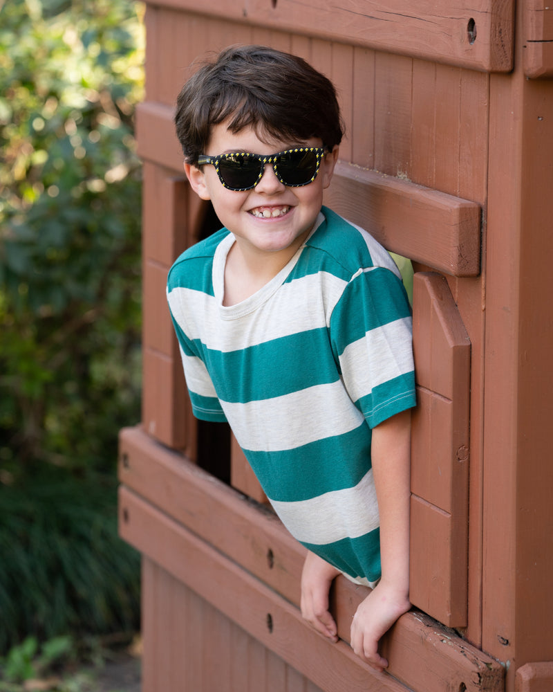 Little boy wearing Sunnies Shades kids polarized sunglasses in a black frame with lightning bolts and non-reflective black lenses.