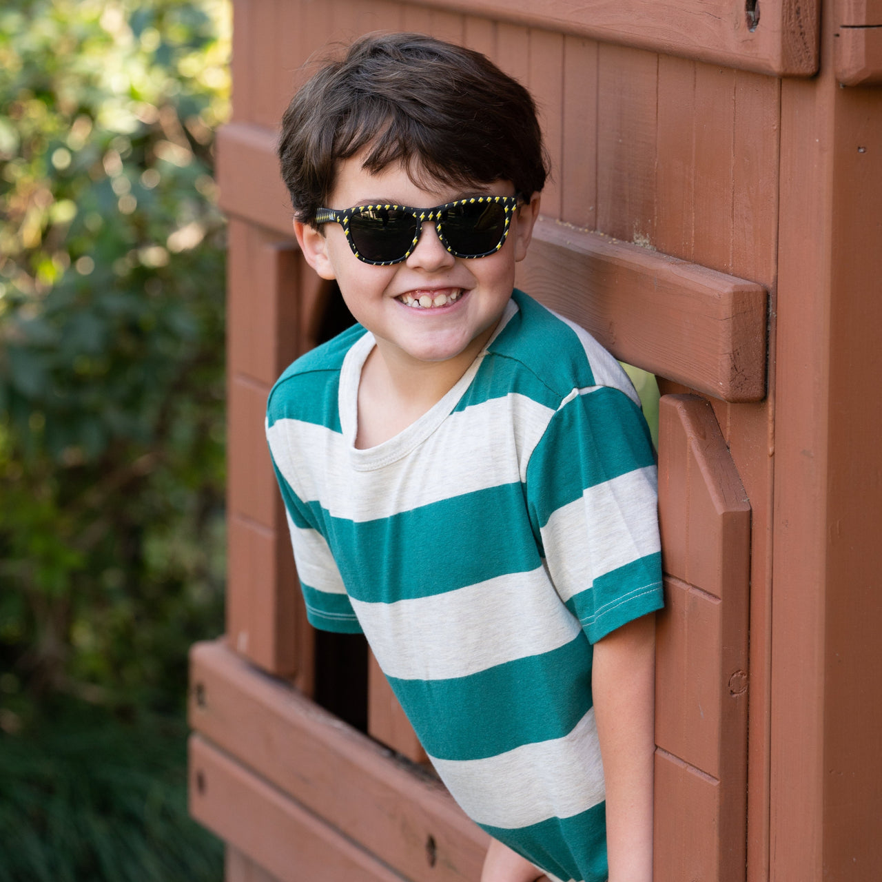 Little boy wearing Sunnies Shades kids polarized sunglasses in a black frame with lightning bolts and non-reflective black lenses.