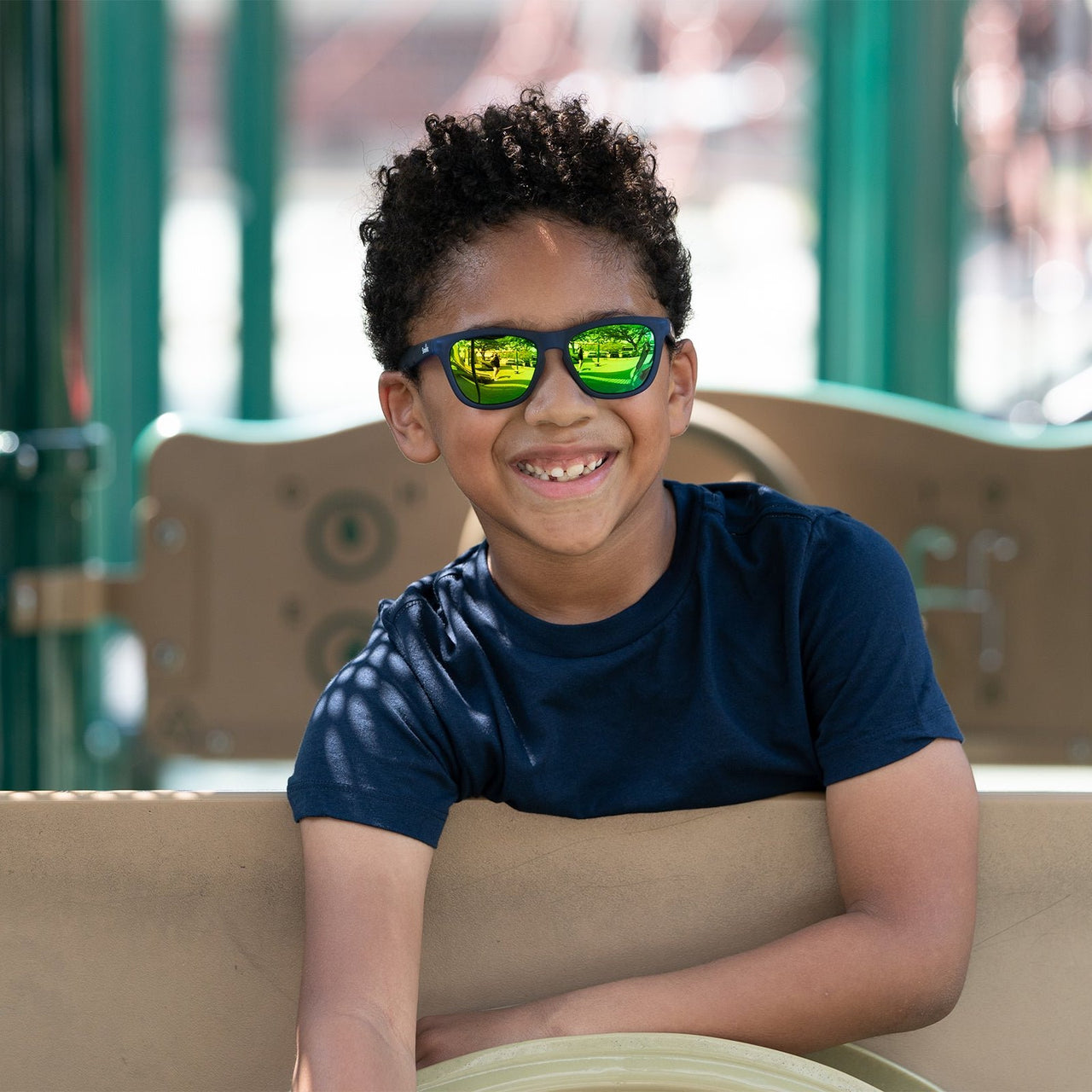 Little boy wearing polarized blue kids sunglasses at a playground