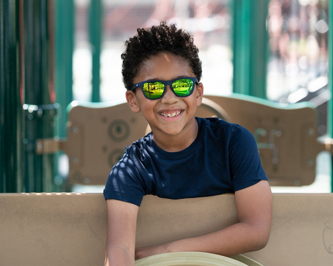 Little boy wearing polarized blue kids sunglasses at a playground